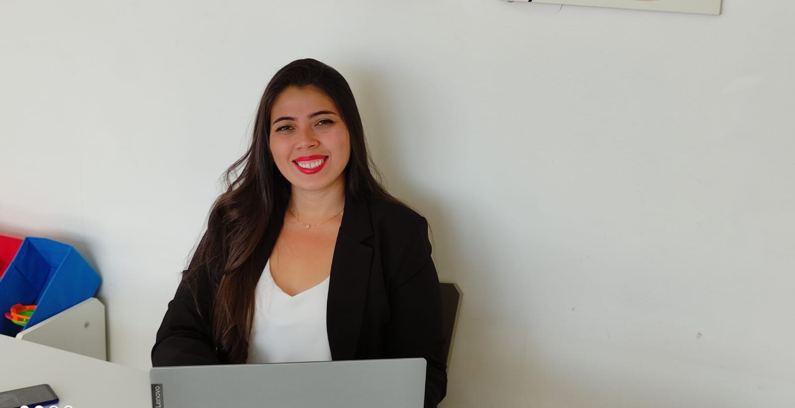 Psicóloga Luana na sala de atendimento com notebook