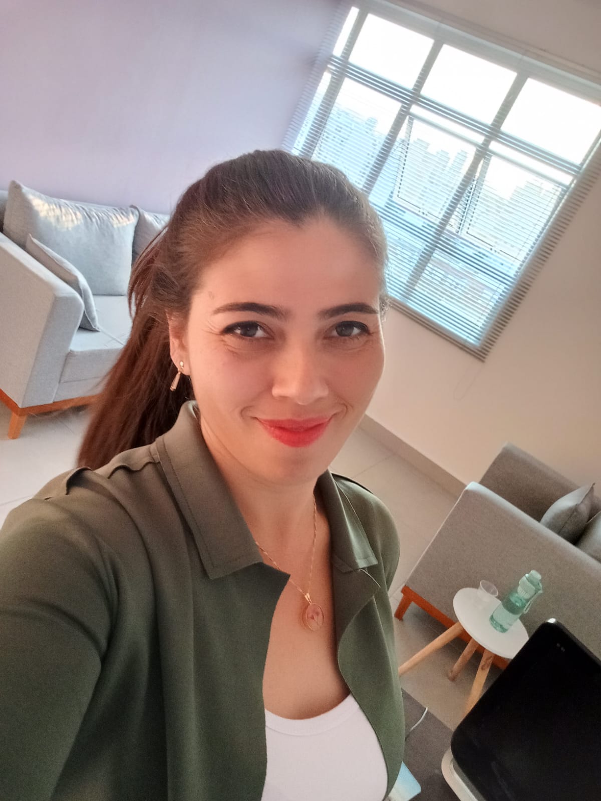 Psicóloga Luana na sala dela ande atende em uma sala grande ampla e aconchegante