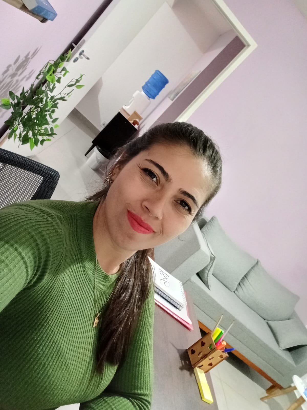 Psicóloga Luana na sala dela com cor do fundo rosa